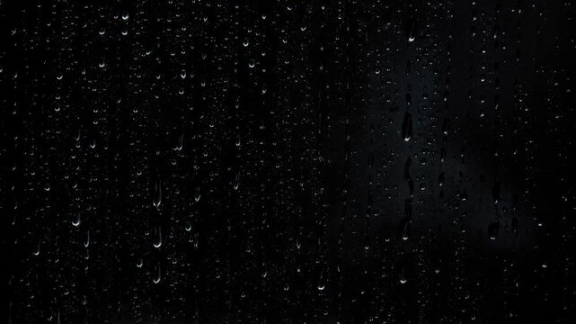 Close up of water droplets on glass window creating dark moody rainy weather background