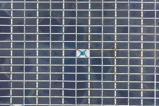 Aerial view of a grid of solar panels with a central blue cooling fan in Liabygda, More og Romsdal, Norway.