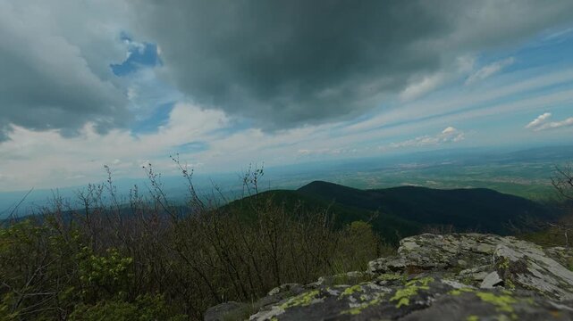 Clouds loom over rolling green mountains. Jastrebac Mountain, Serbia. Timelapse