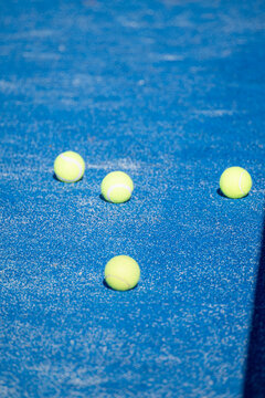 Padel tennis balls scattered on a blue synthetic turf court The Concept of sports activity