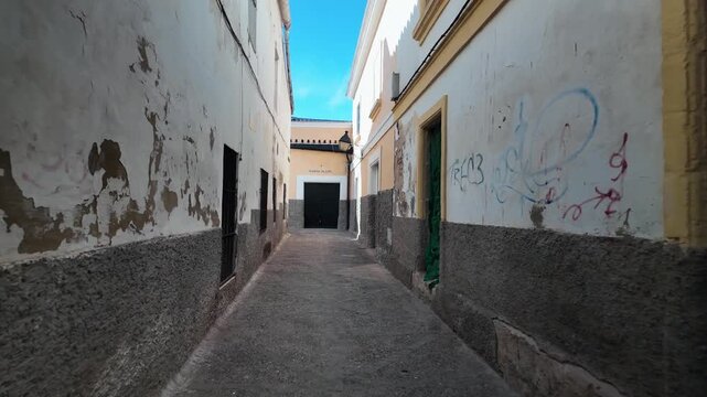Crumbling walls and graffiti in narrow alley, Jerez de la Frontera, Spain