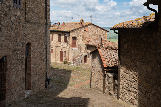 Old stone buildings and cobblestone alley in the medieval village of Castiglione d'Orcia, Tuscany, Italy