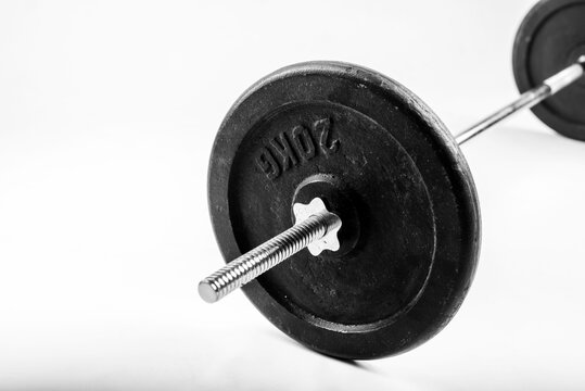 Heavy black iron weight plate for barbell isolated on white background
