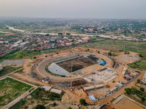 Aerial view of Ahmadu Bello Stadium featuring the oval track and surrounding urban landscape with a river nearby in Kaduna, Kaduna, Nigeria.