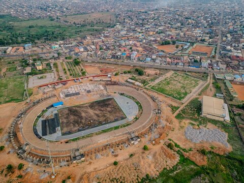 Aerial view of Ahmadu Bello Stadium under construction with surrounding urban landscape, roads, and buildings in Kaduna, Kaduna, Nigeria.