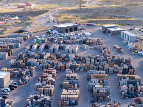 Aerial view of stacks of architectural blocks including bricks, pavers, and cinder blocks arranged in a construction supply yard in Bluffdale, Utah, United States.