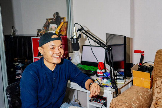 Podcast host at home studio With Computer Equipment and a Microphone