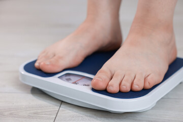 Fototapeta premium Overweight woman on scale at home, closeup