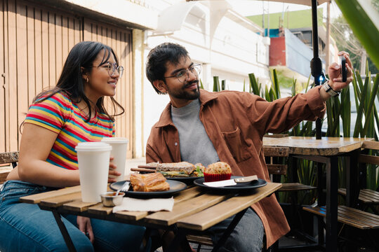 Young couple taking a selfie in a cafe.