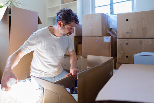 Man Packing Boxes While Moving Into New Home