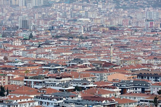 Aerial view of the dense urban landscape with red-tiled rooftops and a minaret in Istanbul, Turkey.