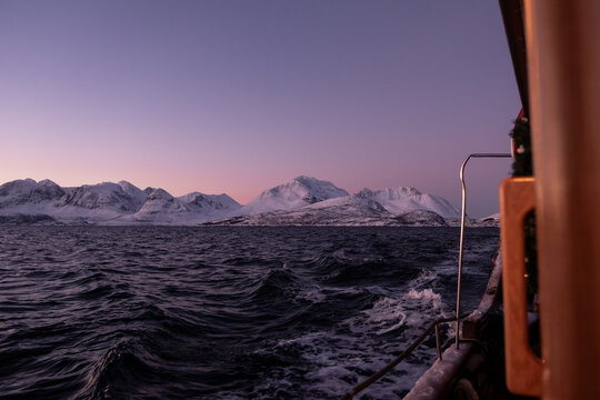 Views of snowy mountain peaks in Norway on board a boat in the arctic 