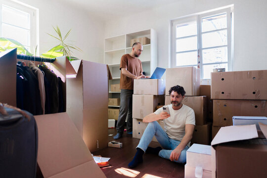 Moving Day: Two Men Packing Boxes in Apartment