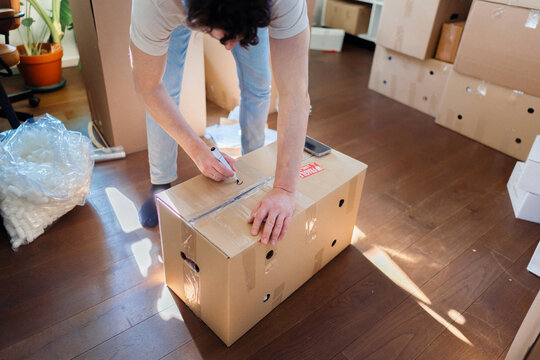 Person Labeling Moving Box During Relocation Packing