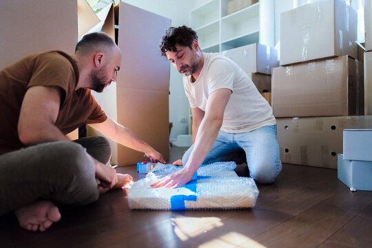 Two Men Packing Boxes During Home Moving Day