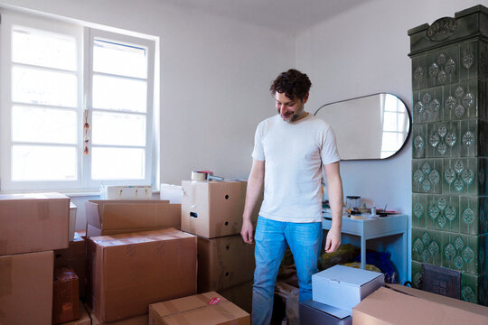 Man Moving Into New Apartment Surrounded By Boxes
