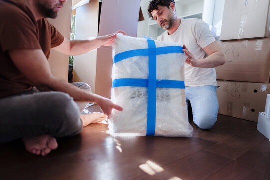 Men Packing and Moving Artwork Wrapped in Bubble Wrap