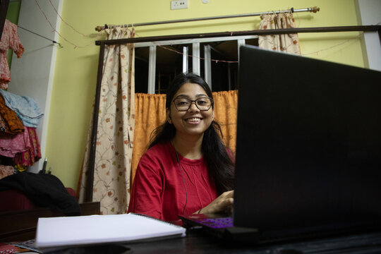 Young Indian woman doing study inside home