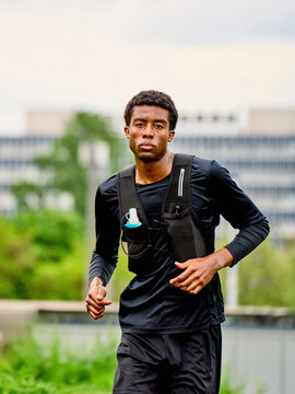 Runner Trains in City Park During Cloudy Day