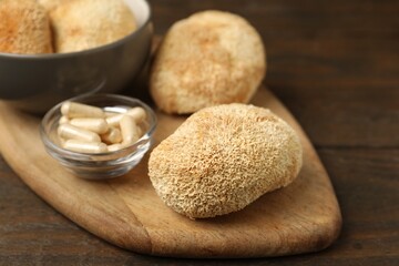 Functional mushrooms and pills on wooden table, closeup © New Africa