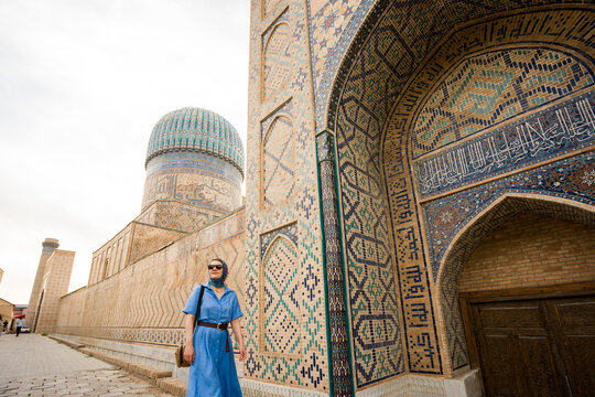 Woman Walking Near Historical Building In Uzbekistan