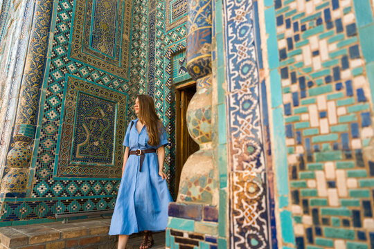 Woman Walking Out of a Blue Tiled Building in Uzbekistan 
