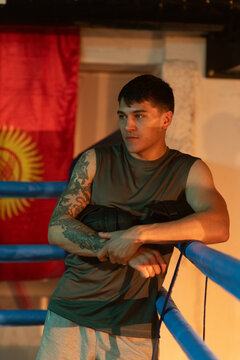 Man coach waits for fighters for sparring in underground boxing gym
