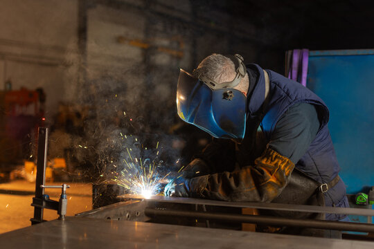 Professional welder joining metal components during industrial fabrication