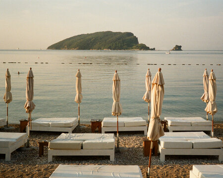 Relaxing Scene at a Beach With Sunbeds and Umbrellas Near Water