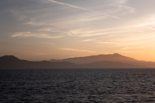 Sunset Over Water With Mountains in the Background