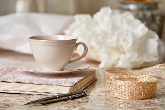 Editorial still life of gift wrapping desk with a winter journal and raffia ribbon.