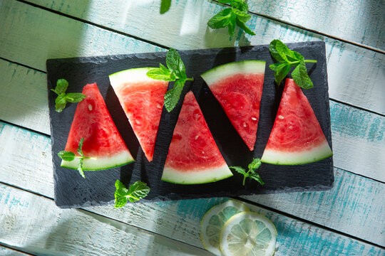 Watermelon slices with mint on slate board