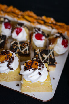 Selecci&oacute;n de mini pasteles surtidos. Primer plano de tarta con crema, chispas de chocolate y durazno. Dulces perfectos para mesa de postres.