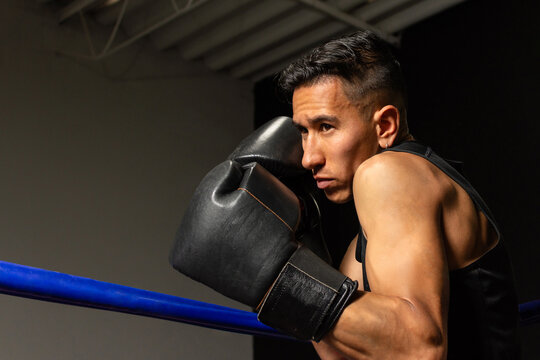 Focused Hispanic boxer in fighting stance ready to throw punch