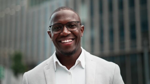 CFO, black businessman, closeup headshot, outdoor near office building. African american business man smiling, works as CFO, building strong client partnerships, leading cross-functional projects.