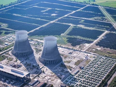Aerial view of the cooling towers of the former Enrico Fermi nuclear power plant surrounded by a large photovoltaic solar park in Trino, Piedmont, Italy.
