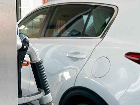 Fuel pump beside a white passenger vehicle. Closeup.