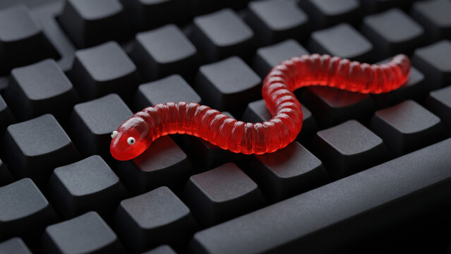 Standalone red gummy computer worm malware on dark computer keyboard, software program