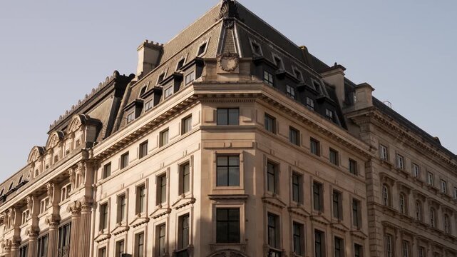 Classical corner building with a stone colonnade and mansard roof