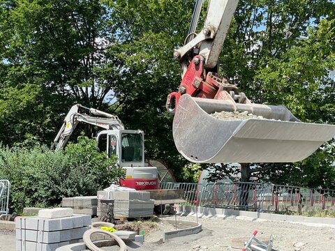Excavator bucket operating at an urban construction site. Heavy construction machinery digs and moves soil during residential development. Civil engineering work. 15.07.26 Archeologicka, Prague, CZ