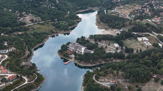 Aerial view of Borsko jezero surrounded by lush forests and a hotel complex in Bor District, Serbia.