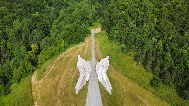 Aerial view of the Tjentiste War Memorial, a concrete monument set amidst lush green forests and rolling hills in Sutjeska National Park, Tjentiste, Republika Srpska, Bosnia and Herzegovina.