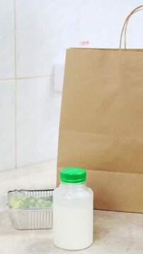 Woman pack ready meal lunch for clients. Delivery of balanced diet food. Chef collect healthy daily menu boxes in plastic takeaway containers. Woman cook on white kitchen. Restaurant business concept
