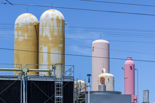 Industrial facility with vertical process vessels, pressure tanks, and utility equipment, illustrating chemical processing, manufacturing infrastructure, and industrial operations