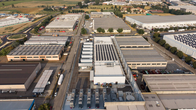 Aerial view of Stack Infrastructure MIL03 data center facility with solar panels on the roof, surrounded by industrial warehouses and roads in Siziano, Lombardia, Italy.