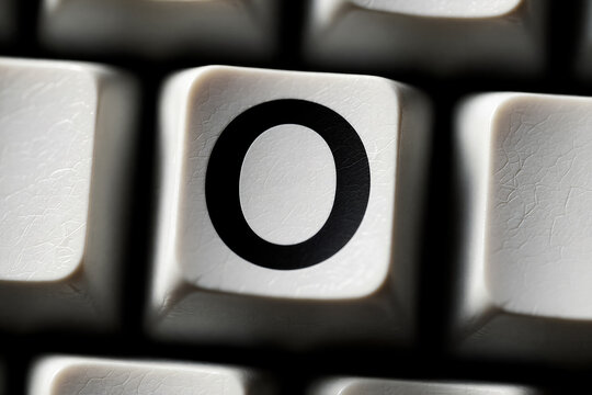 Close-up of a white mechanical keyboard key with the letter O printed on it.