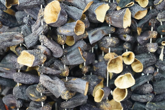 Traditional air-dried eggplants hanging on strings, creating a rustic natural texture. Dried vegetables prepared for winter food storage and traditional cuisine.