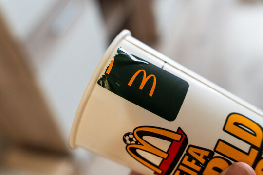 Warsaw, Poland - July 30, 2026: McDonald's branded paper cup with FIFA World Cup promotional design held in hand, showing golden arches logo and tournament branding