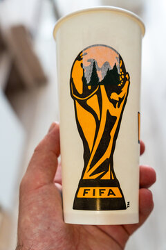 Warsaw, Poland - July 30, 2026: FIFA World Cup trophy logo printed on disposable paper cup held in hand, close-up of official soccer championship merchandise