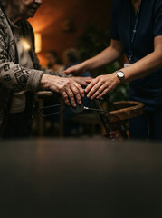 Obraz premium Close up of hands on a walker handle as a caregiver assists an elderly woman